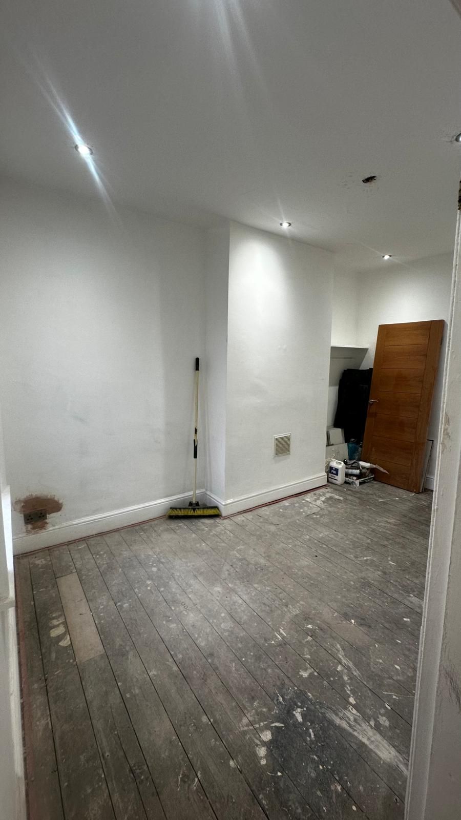 Bedroom with bare floorboards and patched walls